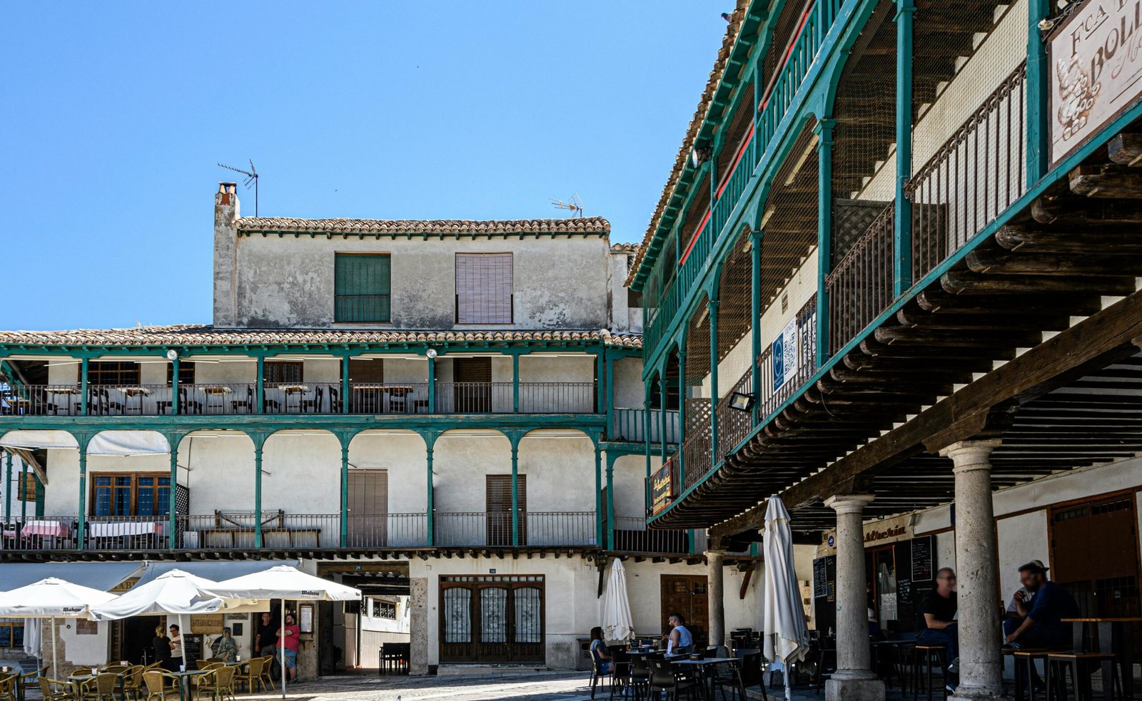 Explore the picturesque town square of Chinchón, Spain, featuring historic architecture and sunny ambiance.